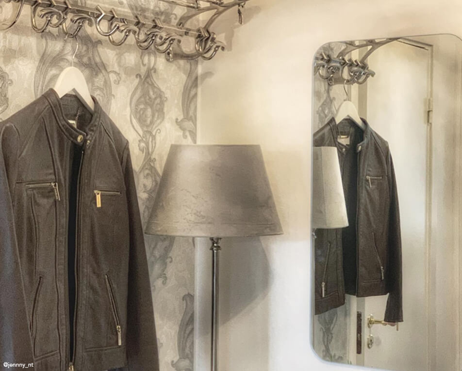 Notranja oprema hodnika - kljuke v kovini, pravokotno ogledalo in siva svetilka